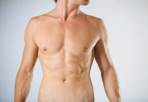 Close up of a man's toned, muscular torso after using Emsculpt Neo for non-surgical body sculpting.