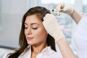 Woman receiving PRP injections into her scalp for hair restoration.