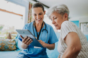 Healthcare provider reviewing a tablet with an older patient during an annual physical.